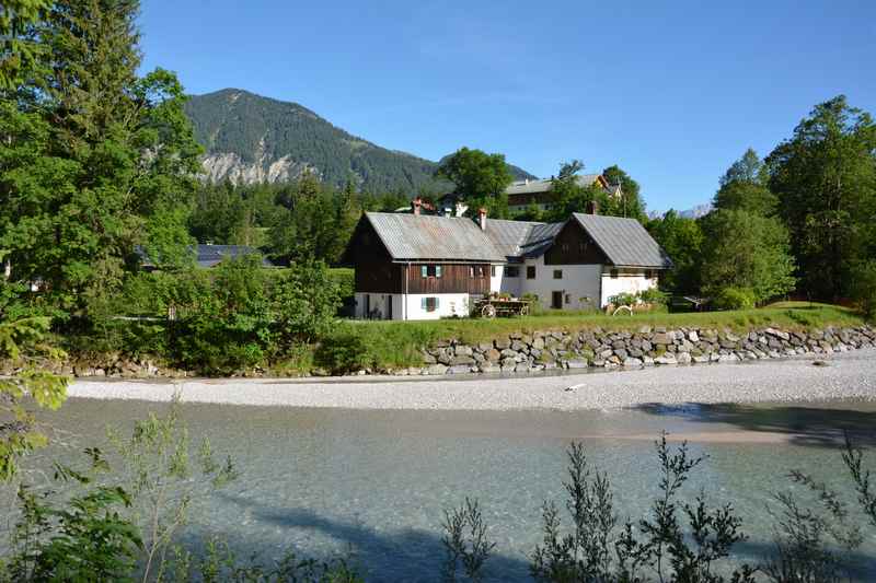 Einige Häuser in Vorderriß stehen nahe der Isar mit dem großen Kiesbett